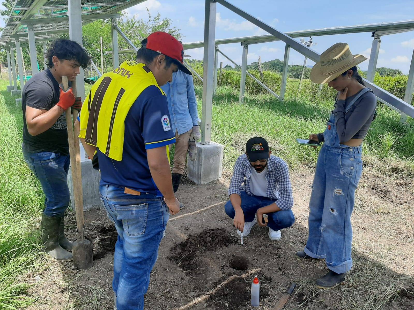 Personas reunidas en el campo estudiando la tierra