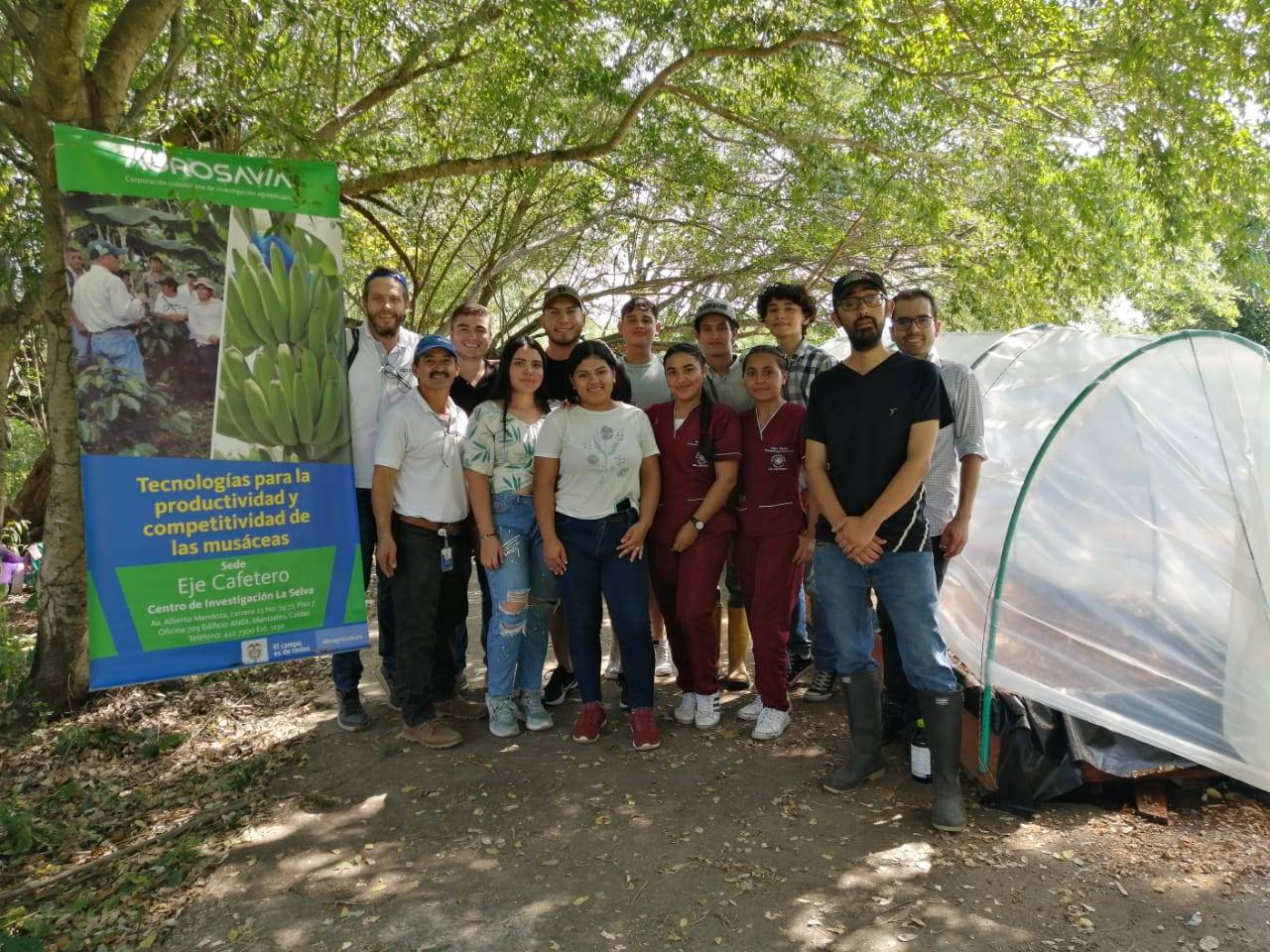 Personas reunidas en el campo al lado de del proyecto de investigación.