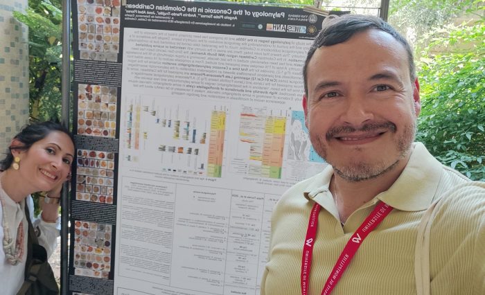 La formación doctoral de Ángelo Plata: un impulso para la investigación geológica en Colombia. En la imagen se observa al investigador y de fondo el poster de su trabajo de investigación