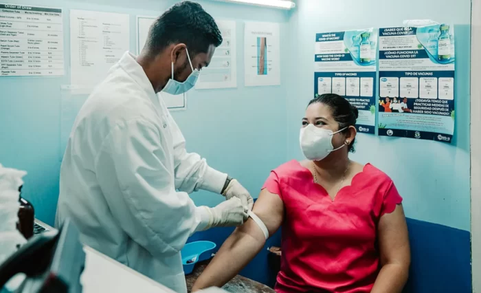 Abiertas las inscripciones para Curso de Equipos Básicos de Atención Primaria en Salud. La imagen es alusiva a la salud pública. se Observa un médico tomándole la presión a una paciente.